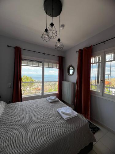 a bedroom with a bed with a view of the ocean at Eleni's Seaview House in Saronida