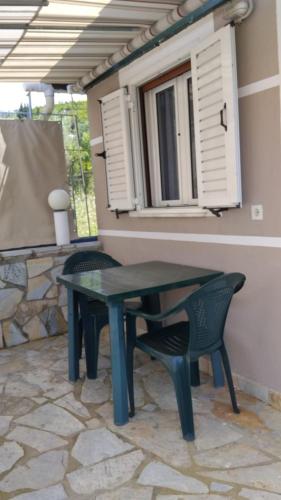 a table and chairs on a patio with a window at Rexhos Studios in Himare