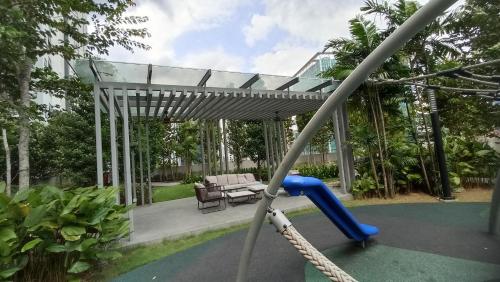 eine Schaukel in einem Garten mit einer Pergola in der Unterkunft Agile Milestone service suite TRX by KL in Kuala Lumpur