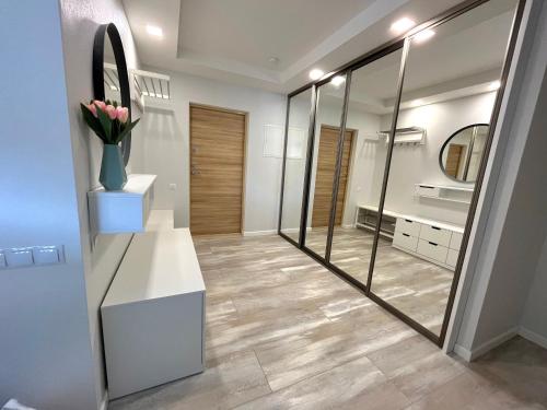 a bathroom with a mirror and a white counter and a sink at Family Nest in Ventspils