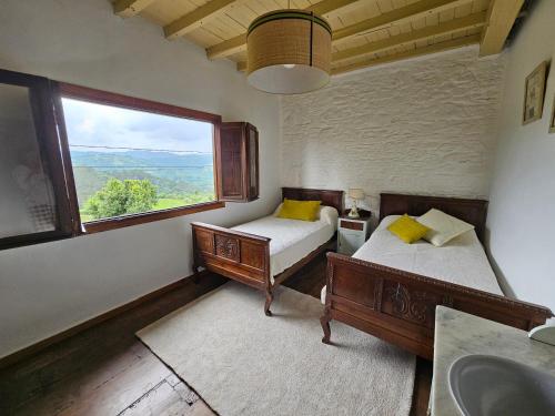 two beds in a room with a window and a sink at Ven al Paraiso! Amanece en Miravalles in Villaviciosa