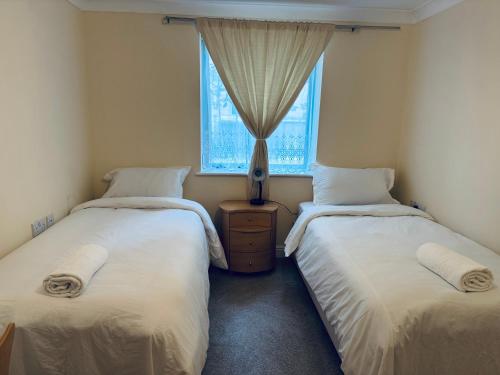 two twin beds in a room with a window at Shared house in OXford city centre in Oxford