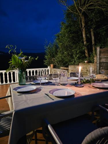 a table with a candle and plates and glasses on it at Ven al Paraiso! Amanece en Miravalles in Villaviciosa