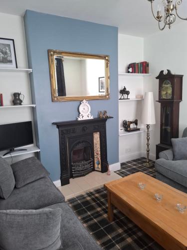 a living room with a fireplace and a mirror at The Duke's Townhouse in Chester