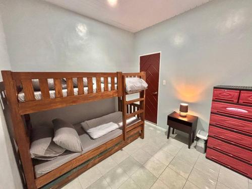 Cette petite chambre comprend 2 lits superposés et une table. dans l'établissement Cozy Manor with Spacious Kitchen and Tub, à General Santos