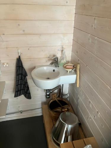 a bathroom with a sink and a metal pot at Nauvo Valmu in Valmoholm