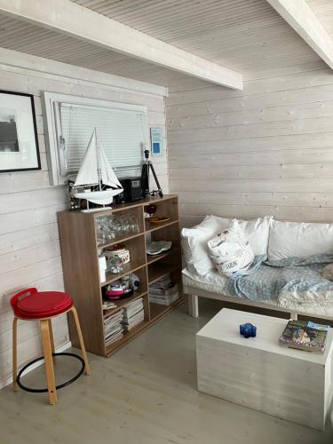a bedroom with a bed and a red stool at Nauvo Valmu in Valmoholm