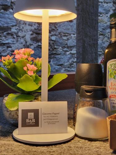 a table with a lamp and a candle and a bottle of soap at B&B Osteria Morganti in Someo