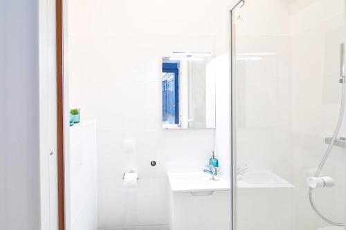 une salle de bain blanche avec un lavabo et une douche dans l'établissement Best 8 Personnes Montrouge, à Montrouge