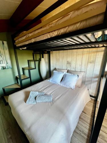 - un grand lit blanc avec 2 serviettes dans l'établissement Maison T3 climatisée parking privé cellier et cour sans vis à vis, à Gruissan