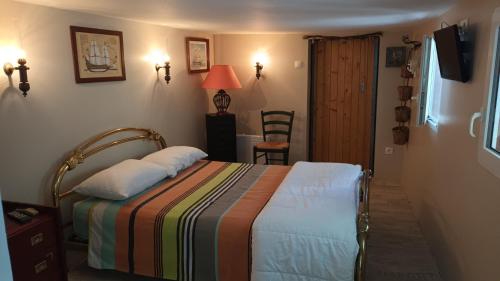 - une chambre avec un lit et une couverture colorée dans l'établissement Un joli jardin méditerranéen, au Cap d'Agde