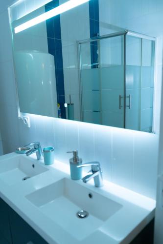 une salle de bain avec un lavabo blanc et un miroir dans l'établissement Maison urbaine familiale, à Béziers