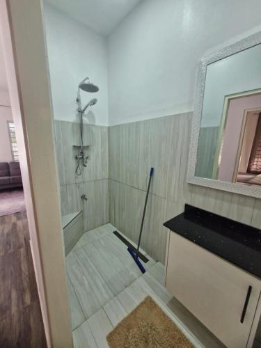 a bathroom with a shower and a mop at Cozy haven apartments in Paramaribo