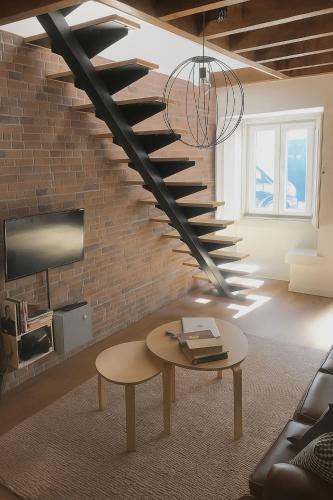 a living room with a spiral staircase in a brick wall at AL Belém 85 in Lisbon