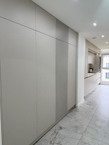 a kitchen with white walls and a tile floor at GOLD Apartment - Lotnisko Katowice-Pyrzowice in Siewierz
