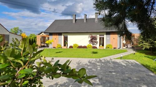 a house with a driveway in front of it at Domki Milo z kominkami in Święta Katarzyna