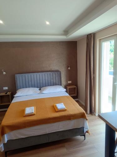 a bedroom with a large bed with two plates on it at Beach apartments Promajna in Promajna