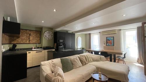 un salon avec un canapé blanc et une cuisine dans l'établissement Appartement Duplex Carnoules, à Carnoules