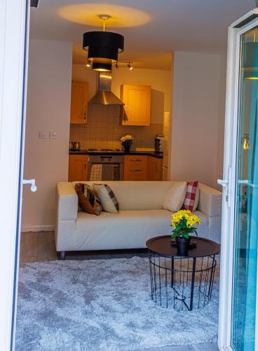 a living room with a white couch and a table at Monea Retreat a Modern 2bedroom and 2 bathroom apartment in Coventry in Coventry