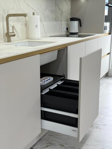 a kitchen with a sink and an open drawer at GOLD Apartment - Lotnisko Katowice-Pyrzowice in Siewierz