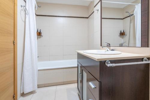 a bathroom with a sink and a bath tub at Palmera del mar in Alicante