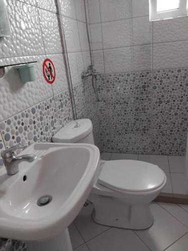 a bathroom with a white toilet and a sink at Rexhos Studios in Himare