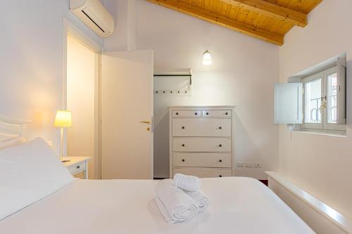 a bedroom with a white bed with towels on it at Atena at Como Duomo in Como