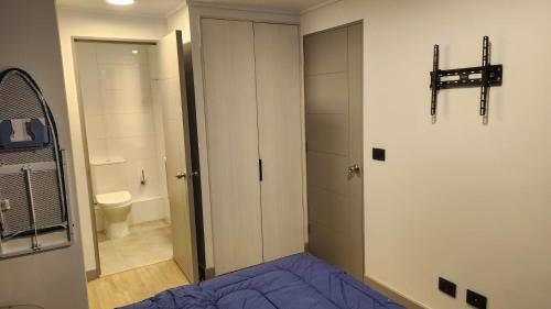 a bedroom with a bed and a bathroom with a toilet at Deptos Boutique en pleno centro de Santiago in Santiago