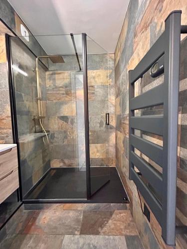 une douche avec une porte vitrée dans une salle de bain dans l'établissement Sea Blue Les Roches Marines, au Cap d'Agde