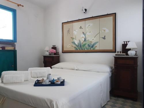 カーラ・リベロットにあるBeachfront villa, right ON SAND!のベッド2台が備わる部屋、壁に絵が飾られた部屋