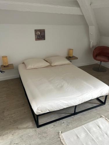 Cette chambre comprend un grand lit et une chaise. dans l'établissement Duplex T4 vue mer, à La Seyne-sur-Mer