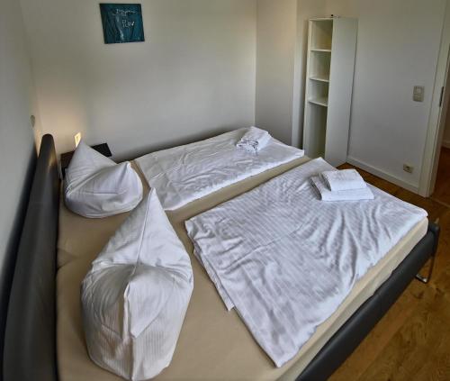 two beds in a room with white sheets and pillows at Fischstübchen Neeberg Fewo 4 – Schwalbennest in Krummin