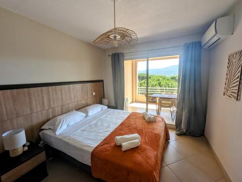 une chambre avec un lit et un balcon avec une table dans l'établissement Apartment with pool view Salina Bay Porto-Vecchio, à Porto-Vecchio