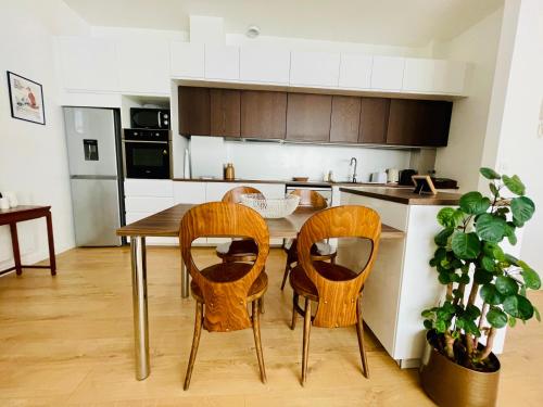 une cuisine avec une table en bois et quatre chaises dans l'établissement Liberté - Grand appartement 4 pers avec parking Lille Centre, à Lille