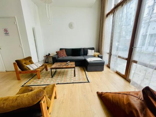 un salon avec un canapé et une table basse dans l'établissement Liberté - Grand appartement 4 pers avec parking Lille Centre, à Lille