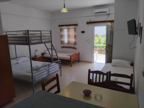 a room with two bunk beds and a table at Rexhos Studios in Himare