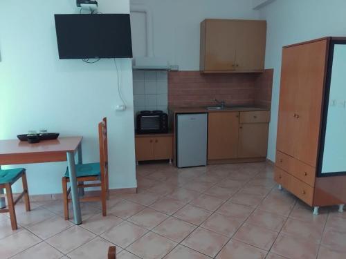 a kitchen with a table and a table and a refrigerator at Rexhos Studios in Himare