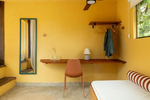a bedroom with a bed and a mirror and a chair at O Portalzinho in Paraty