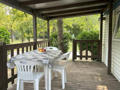 a table and two chairs on a porch at AdriaCamp Mobile Homes Rosapineta in Rosapineta