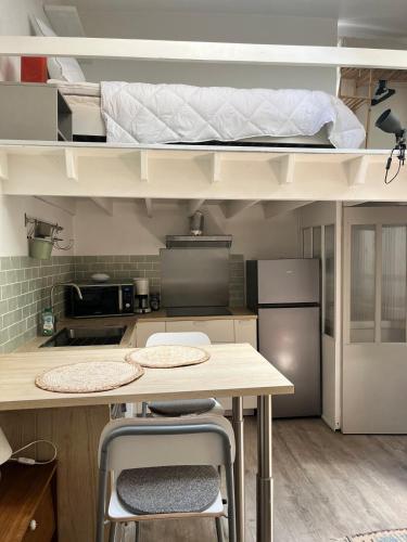 une cuisine avec une table et deux tabourets de bar dans l'établissement Studio with mezzanine St Michel, à Bordeaux