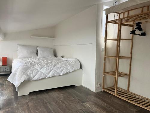 - une chambre avec un lit blanc et une étagère dans l'établissement Studio with mezzanine St Michel, à Bordeaux