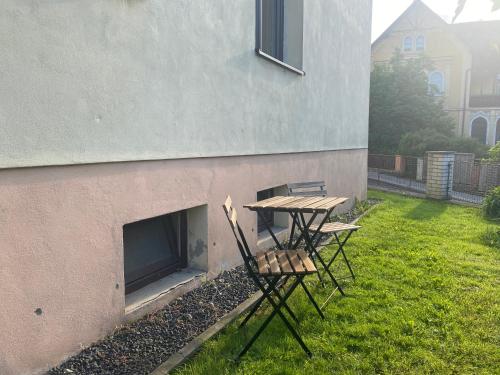a picnic table and two chairs next to a fireplace at Apartmán Česká Kamenice in Česká Kamenice