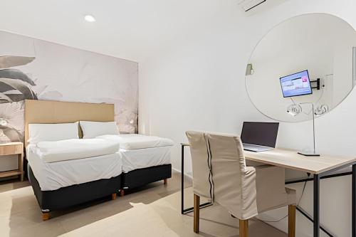 a bedroom with a bed and a desk with a laptop at Oasis en Palermo c/ Terraza, Jacuzzi y Playroom in Buenos Aires