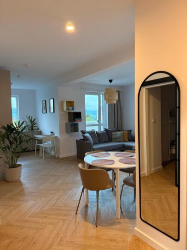 a living room with a table and a mirror at Apartament z wielkim tarasem Kłodzko ul Letnia in Kłodzko