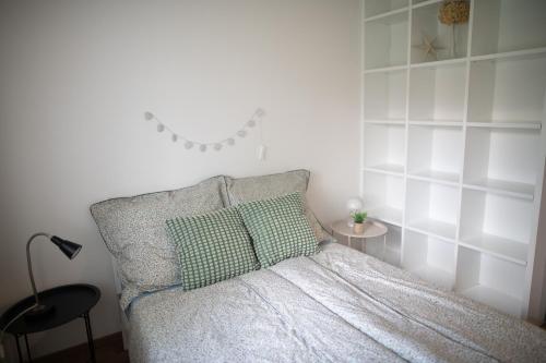 a white bedroom with a bed and a lamp at Prázdninový apartmán Pohoda in Strážnice
