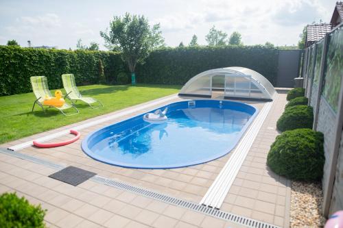 a small swimming pool with a cover in a yard at Prázdninový apartmán Pohoda in Strážnice