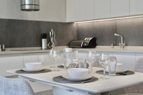 a kitchen with a table with wine glasses on it at City Rooms Greenwood in Odesa