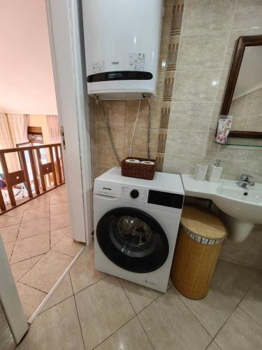 a washing machine in a bathroom next to a sink at Sea view and more in Bŭnzareto