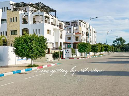 a row of white buildings on a street at LuxuryStay by Al Amir in Martil