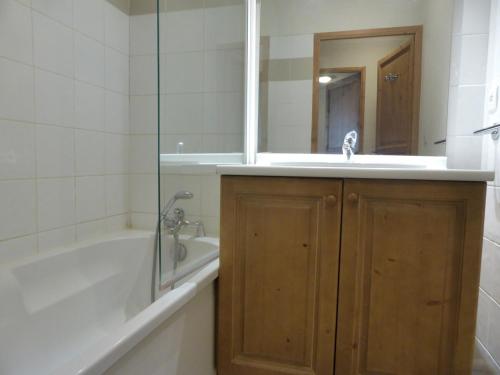 une salle de bain avec une baignoire, un lavabo et un miroir dans l'établissement Grand Panorama 1 bedroom - sleeps 4, Parking, Pool, Next to Ski Lift, à Saint-Gervais-les-Bains